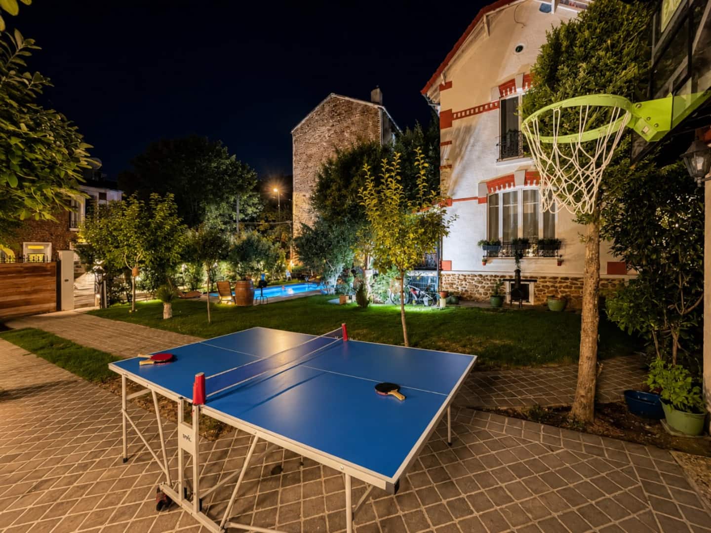 Espace de jeu extérieur avec table de ping-pong dans l'ambiance du soir.